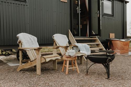 a group of chairs and a table and a grill at Brackenslack Shepherds Huts in Maulds Meaburn