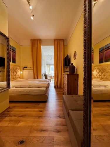 a mirror in a bedroom with two beds and a couch at Provence am Kurpark in Boppard