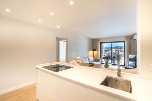 une cuisine avec un évier et un salon dans l'établissement Appartement Port Grimaud, à Grimaud