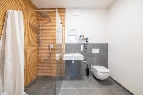 Un baño con ducha, lavabo e inodoro. en Pine Living, en Múnich