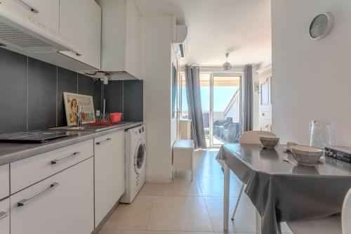 une cuisine avec des armoires blanches et un comptoir dans l'établissement Evasion Maritime, à Fréjus