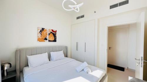 a white bedroom with a bed with white sheets at Luxury 1-Bedroom Apartment At Burj Crown. in Dubai