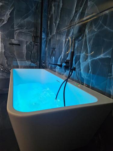 a bath tub with a blue water in a room at Hotel Centrum Malbork in Malbork