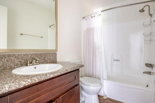 a bathroom with a sink and a toilet and a shower at Blueground Glendale pool AC nr Americana LAX-1319 in Glendale