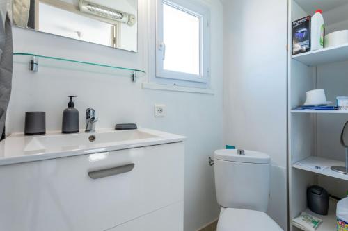 une salle de bain blanche avec un lavabo et des toilettes dans l'établissement Evasion Maritime, à Fréjus