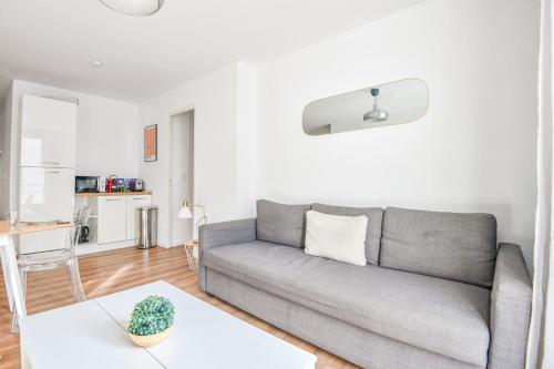 un salon avec un canapé gris et une table dans l'établissement Appart 3 ch avec balcon à la Joliette, à Marseille