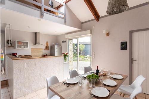 une cuisine et une salle à manger avec une table et des chaises en bois dans l'établissement Le Jardin d'Armor - Grand jardin parking privé, à Lamballe