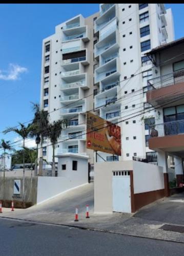 a tall white building with a sign in front of it at Beautiful and Luxury apartment in Santiago de los Caballeros
