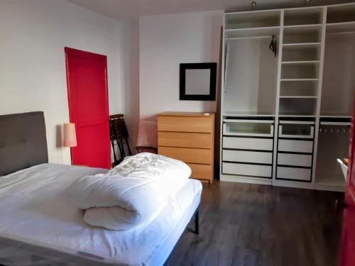 - une chambre avec un lit, une commode et une fenêtre rouge dans l'établissement Appartement Centre historique Tout Confort, à Montpellier