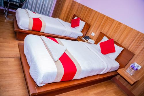 two beds in a room with red and white pillows at Great Doors Thamel in Kathmandu
