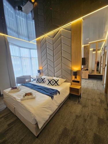 a bedroom with a large bed in a room with windows at Hotel Centrum Malbork in Malbork