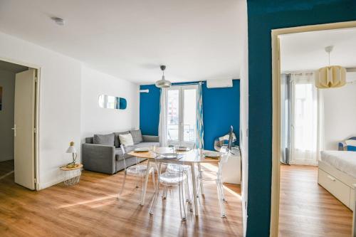 un salon avec une table et un canapé dans l'établissement Appart 3 ch avec balcon à la Joliette, à Marseille