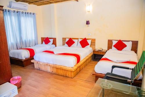 a bedroom with two beds with red pillows at Great Doors Thamel in Kathmandu