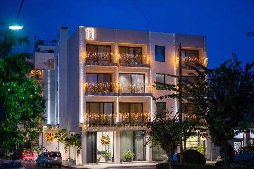 Un edificio blanco con balcones a los lados. en 11Suites, en Egio