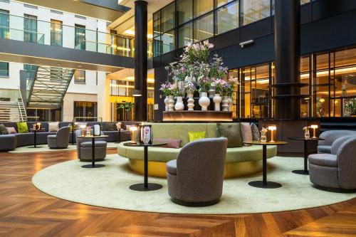a lobby with a couch and chairs in a building at Hotel Kö59 Düsseldorf - Member of Hommage Luxury Hotels Collection in Düsseldorf
