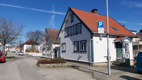 a white house with a parking sign on a street at Nelly's Home in Stavanger