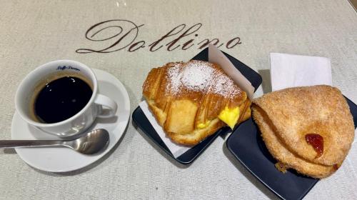 a sandwich on a plate next to a cup of coffee at Affittacamere THE SHUTTLE in Livorno