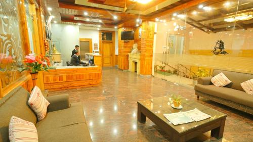 a living room with a couch and a coffee table at Hotel Shiva Sanctuary by DLS Hotels, McLeod Ganj in Dharamshala
