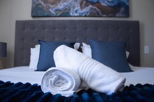 a rolled up towel sitting on top of a bed at Ocean Breeze Hotel in Strand