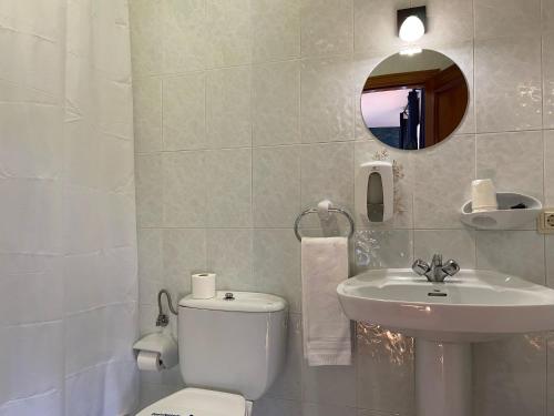 a bathroom with a white toilet and a sink at Hostal La Trucha Sanabria in Puebla de Sanabria