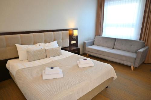a hotel room with a bed and a couch at Hotel Centrum Malbork in Malbork