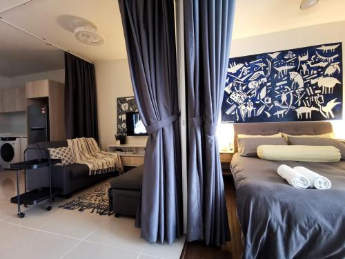 een slaapkamer met een bed en een bank in een kamer bij The Shore Artsy Studio Kota Kinabalu in Kota Kinabalu