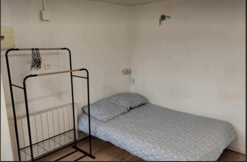 une chambre avec un lit dans une pièce blanche dans l'établissement La terrasse - Hyper Centre et Proche Plage, à Dunkerque