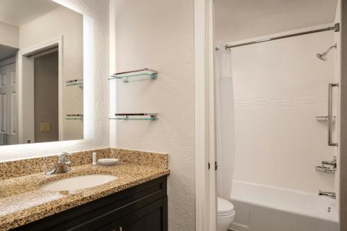 a bathroom with a sink and a toilet and a mirror at Residence Inn Pasadena Arcadia in Arcadia