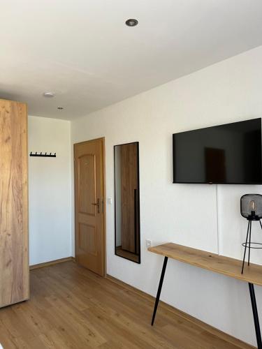 a room with a flat screen tv on a wall at Weingut Lindenhof in Thörnich