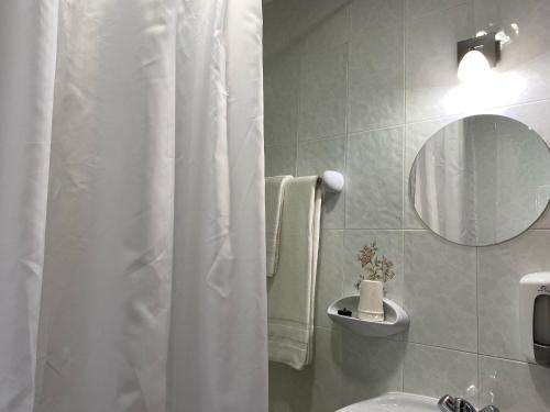 a bathroom with a white shower curtain and a sink at Hostal La Trucha Sanabria in Puebla de Sanabria