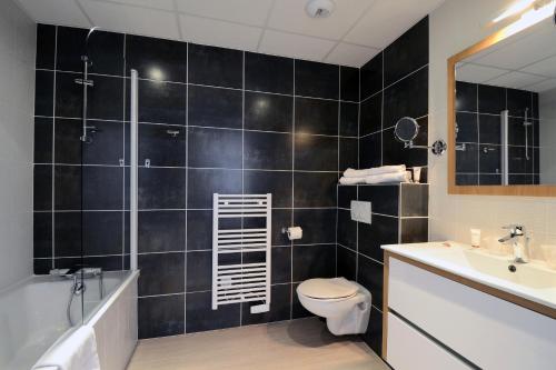 La salle de bains est pourvue de toilettes, d'une baignoire et d'un lavabo. dans l'établissement Odalys City Montpellier Les Occitanes, à Montpellier