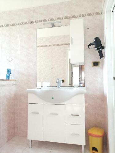 a bathroom with a white sink and a mirror at Casa Centro in Favignana