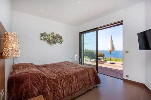 une chambre avec un lit et une vue sur l'océan dans l'établissement Villa avec vue imprenable sur la mer à Pietrosella - 270 m², à Pietrosella