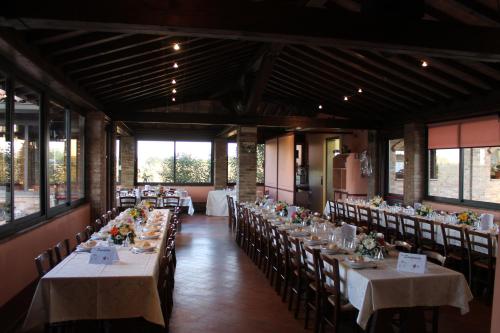 カステルヴェトロ・ディ・モーデナにあるAgriturismo Le Casetteの花の椅子とテーブルが置かれた宴会場