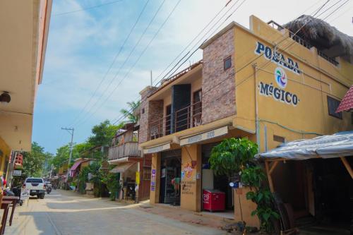 een straat met een geel gebouw met een winkel bij Posada El Mágico in Mazunte