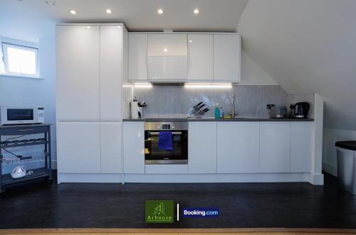 a kitchen with white cabinets and a stove top oven at One Bedroom Apartment By Arhouse Apartments Short Lets & Serviced Accommodation Kingston With Free WiFi in Kingston upon Thames