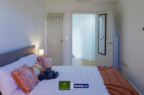 a bedroom with a large white bed with pillows at One Bedroom Apartment By Arhouse Apartments Short Lets & Serviced Accommodation Kingston With Free WiFi in Kingston upon Thames