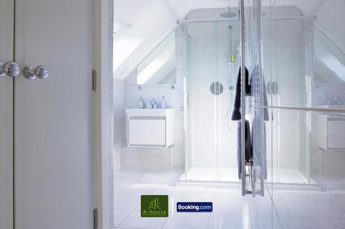 a white bathroom with a shower and a sink at One Bedroom Apartment By Arhouse Apartments Short Lets & Serviced Accommodation Kingston With Free WiFi in Kingston upon Thames