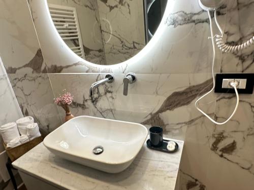 a white sink in a bathroom with a mirror at Sweet Rooms in La Spezia