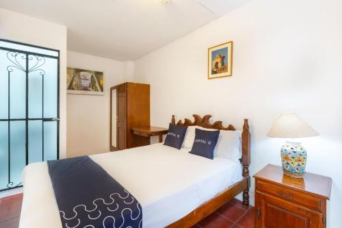 a bedroom with a white bed and a window at Capital O Posada La Casa De La Tia, Oaxaca in Oaxaca City