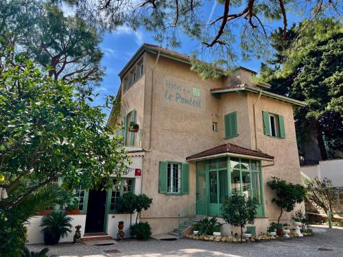 a building with green shutters on it at Hotel Le Ponteil in Antibes