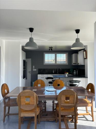- une cuisine avec une table à manger et des chaises dans l'établissement Maison proche plages du débarquement, à Bernesq