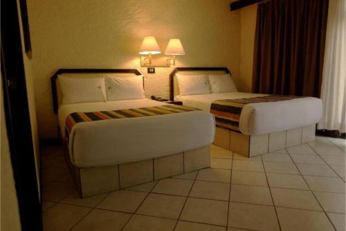 a hotel room with two beds and a couch at Hotel Del Portal, Puebla in Puebla
