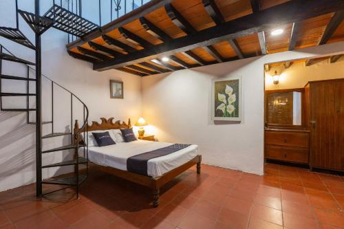 a bedroom with a bed and a ladder in it at Capital O Posada La Casa De La Tia, Oaxaca in Oaxaca City