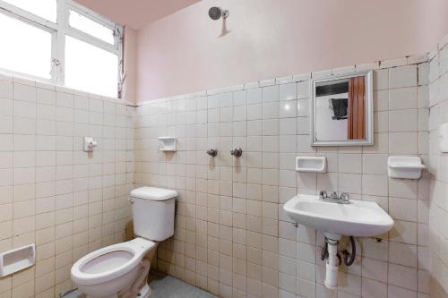 a bathroom with a toilet and a sink at OYO Hotel Emperador, Oaxaca in Oaxaca City