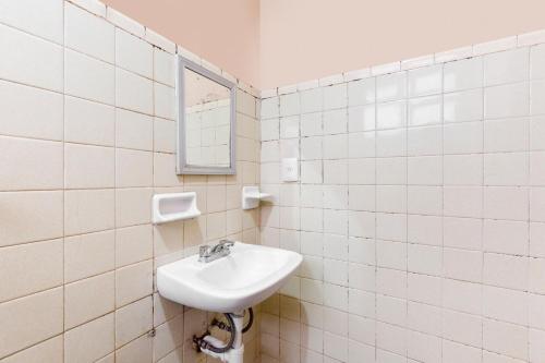 a white bathroom with a sink and a mirror at OYO Hotel Emperador, Oaxaca in Oaxaca City