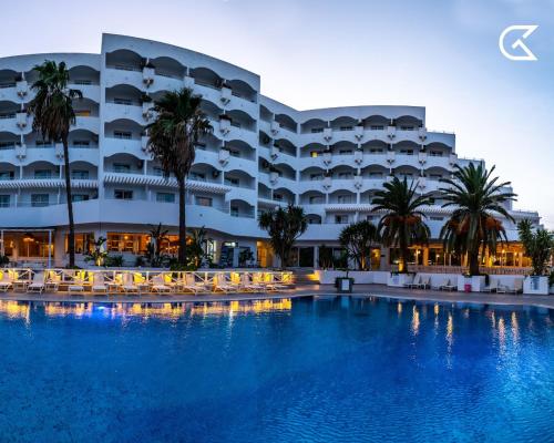 a hotel with a swimming pool in front of a building at Golden Tulip Président Hammamet in Hammamet