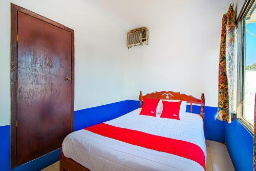 a bedroom with a bed with red and blue at OYO Hotel Posada Los Faroles,Tabasco in Villahermosa