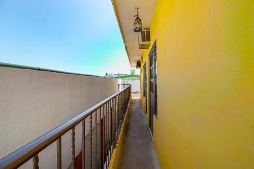 an empty hallway of a yellow building with a balcony at OYO Hotel Posada Los Faroles,Tabasco in Villahermosa