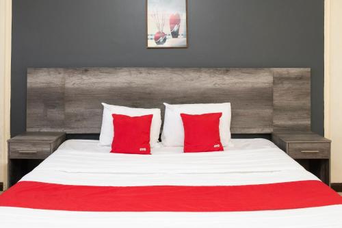 a bedroom with a large bed with red pillows at OYO Hotel Real Del Sur, Estadio Chihuahua in Chihuahua